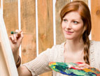 redhead woman painting with palette on canvas